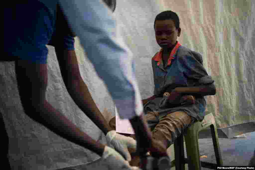 A boy has an infected wound cleaned in the dressings tent of a Médecins Sans Frontières (MSF) clinic set up at the camp for displaced people in the grounds of the United Nations Mission to South Sudan (UNMISS) base in Juba.
