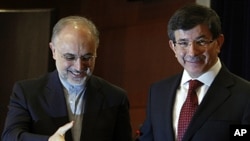 Turkish Foreign Minister Ahmet Davutoglu, right, and his Iranian counterpart Ali Akbar Salehi leave after a news conference in Ankara, Turkey, October 21, 2011.