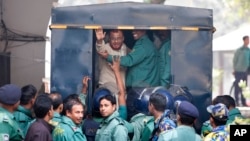 A.T.M. Azharul Islam, asisten sekretaris jenderal partai Jamaat-e-Islami, melambaikan tangannya memasuki mobil polisi setelah mengikuti sidang pengadilan yang menjatuhkan vonis hukuman mati untuknya di Dhaka, Bangladesh, 30/12/2014.