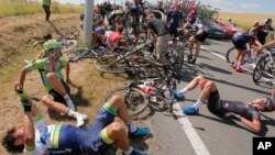 Des dizaines de cyclistes, à terre, après une chute terrible au cours de la troisième étape de la course cycliste du Tour de France sur 159,5 kilomètres (99,1 milles), partie d’Anvers avec pour point d’arrivée à Huy, en Belgique, le lundi 6 Juillet, 2015.