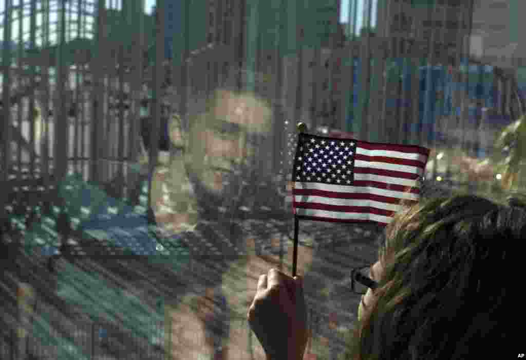 Những người nhà của nhân viên Đại sứ quán Mỹ nhìn ra ngoài khu vực làm lễ trước khi bắt đầu lễ thượng kỳ tại Đại sứ quán Mỹ mới mở cửa trở lại ở Havana, Cuba.