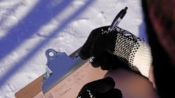 The fourth grader Falis Asair takes notes while wearing gloves during an outdoor class at the Gerald Talbot School, in Portland, Maine. Photo taken on Monday, December 8, 2020. (AP Photo/Robert F. Bukaty)