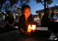 A woman lights candles during a service for peace on the Korean Peninsula near the U.S. Embassy in Seoul, South Korea, Aug. 31, 2017. The United States flew some of its most advanced warplanes in bombing drills with ally South Korea on Aug. 31, a clear warning after North Korea launched a midrange ballistic missile designed to carry nuclear bombs over Japan earlier this week, South Korea's military said.