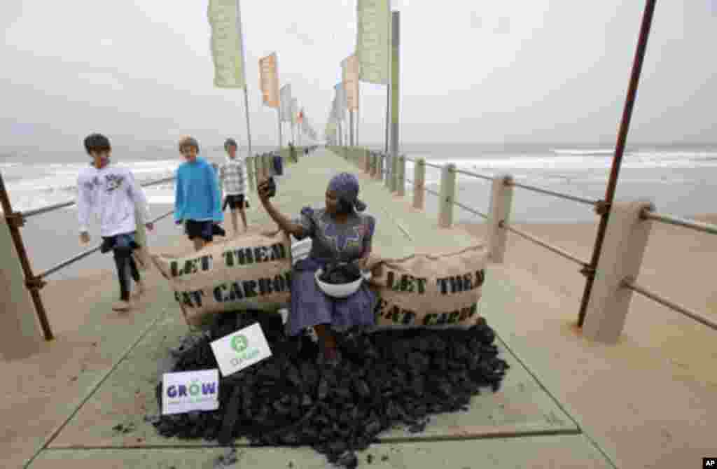 Busi Ndlovu, a member of the aid group Oxfam, stages a protest against the use of coal-based energy on Durban's beachfront, December 9, 2011. The city is hosting the United Nations Climate Change Conference (COP17) meeting. REUTERS/Mike Hutchings