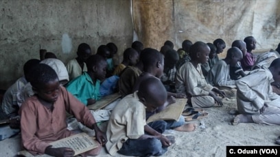 Almajirai in Maiduguri read scriptures from the Quran on wooden slates.