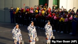 Chinese astronauts, from left, Tang Hongbo, Nie Haisheng,a nd Liu Boming on June 17, 2021. (AP Photo/Ng Han Guan)