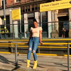 Claire Muhlawako Madzura (kini berusia 16 tahun), berpose dengan kaus kaki kuning di peron kereta api di Manchester, Inggris, 22 September 2019 . (Foto: Elorm Fiavor via AP)