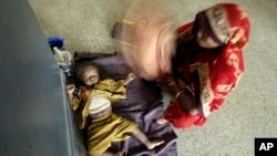 Indian mother fans her child with her sari as the child awaits treatment for diarrhea at a government-run children's hospital in Allahabad, India, June 25, 2009.