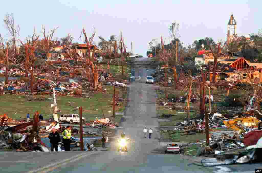 May 23: Emergency workers and residents walk through a neighborhood after a devastating tornado hit Joplin, Missouri. At least 125 people have died since the tornado struck the town. (Reuters)