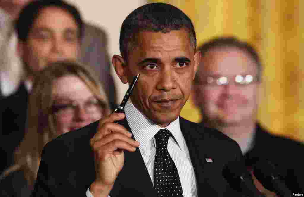 U.S. President Barack Obama holds up a pen as he delivers a statement on the U.S. "Fiscal Cliff" in the East Room of the White House in Washington, November 9, 2012. REUTERS/Kevin Lamarque (UNITED STATES - Tags: POLITICS BUSINESS) 
