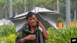 A man walks along a boulevard under the slight rain in Manila, Philippines, Oct. 16, 2016. Typhoon Sarika, with sustained winds of 130 kilometers (80) miles per hour and gusts of 220 kph (136mph), has slammed into the northeastern Philippines.