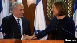 Israel's Prime Minister Benjamin Netanyahu (L) shakes hands with former Foreign Minister Tzipi Livni, head of the centrist Hatenuah party, during their joint statement at the Knesset, the Israeli parliament, in Jerusalem, February 19, 2013.