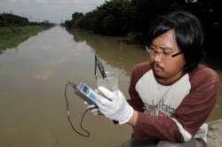 Prigi Arisandi saat memeriksa air yang terkontaminasi di sungai Brantas, Surabaya. (dok: REUTERS/Sigit Pamungkas)