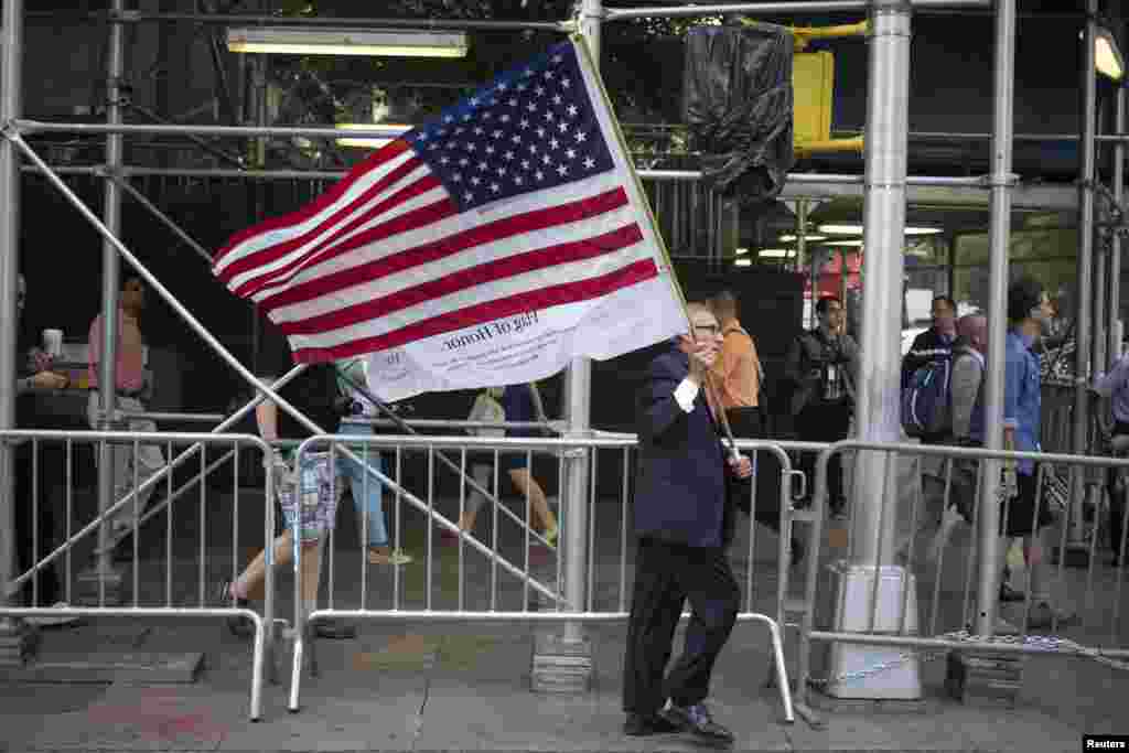 ایک امریکی شہری اپنے ملک کا جھنڈا اٹھائے ہوئے