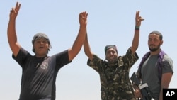 Libyan rebel fighters celebrate as they drive into the coastal city of Zawiyah, August 15, 2011.