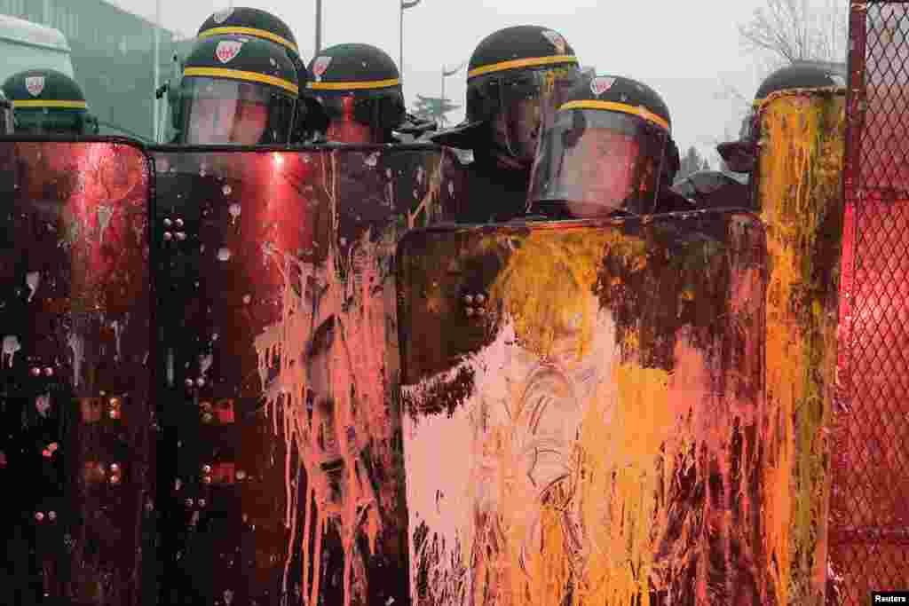 French CRS riot police are covered with paint during clashes with demonstrators in front of tire-maker Goodyear Dunlop's France headquarters in Rueil Malmaison, near Paris.