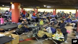 Refugees rest in a parking garage in the main rail station in Salzburg Austria, Sunday, Sept. 13, 2015.