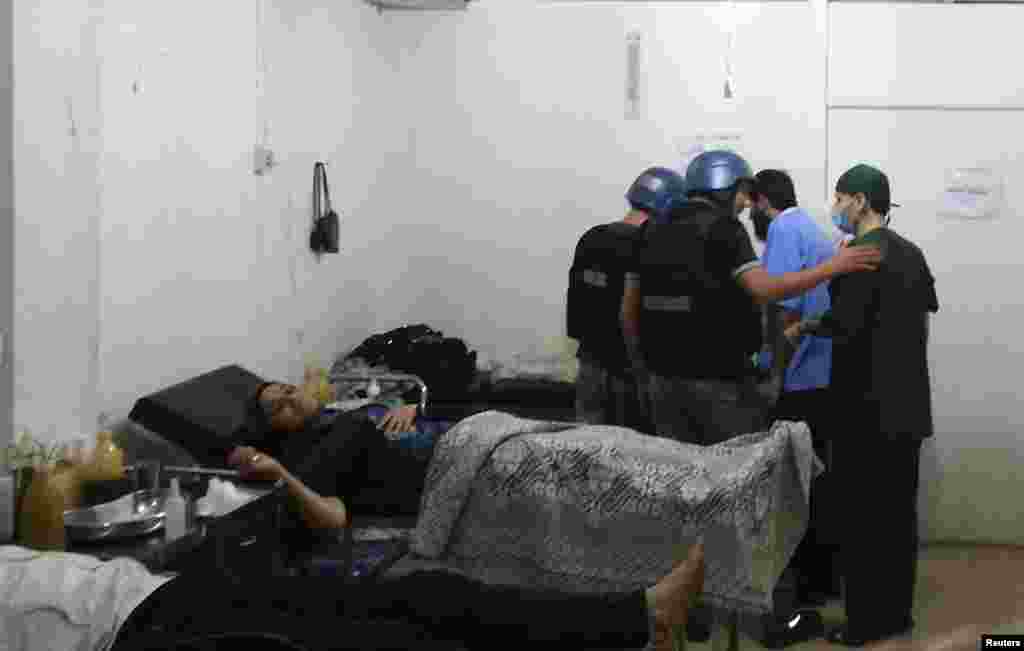 U.N. chemical weapons experts visit a hospital where wounded people affected by a suspected gas attack are being treated, in a southwestern Damascus suburb, August 26, 2013. 