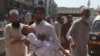 FILE - Family members rush a boy to a hospital after receiving a polio vaccination, in Peshawar, Pakistan, April 22, 2019. 