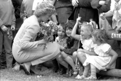 Putri Diana berlutut, saat berbicara dengan anak-anak dalam lawatannya di Makedonia, Australia, 11 Februari 1985. (AP)