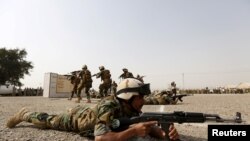 Fuerzas de seguridad iraquíes demuestran sus habilidades en una ceremonia de graduación en Camp Taji, una base del ejército iraquí en Bagdad, el 21 de febrero de 2016. Reuters.
