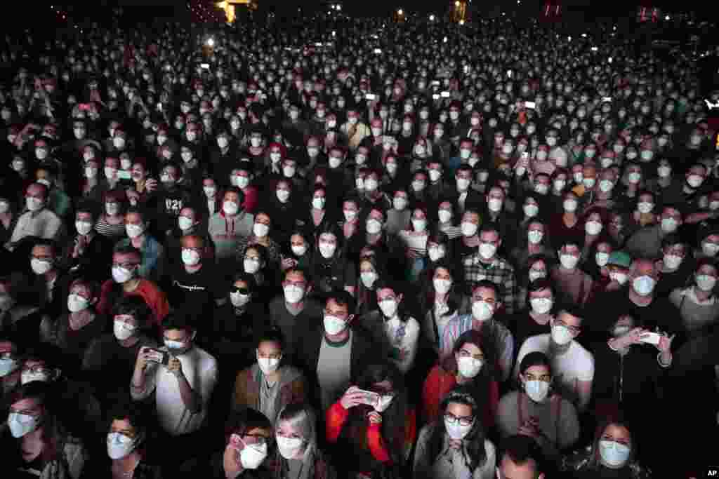 People using face masks attend a music concert in Barcelona, Spain, March 27, 2021.