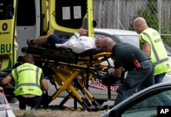 Ambulance staff take a man from outside a mosque in central Christchurch, New Zealand, Friday, March 15, 2019.