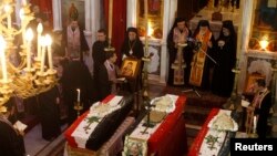 Clerics and other people attend the funeral of three men at Catholic Patriarchate in Damascus, Syria, on September 10, 2013. 