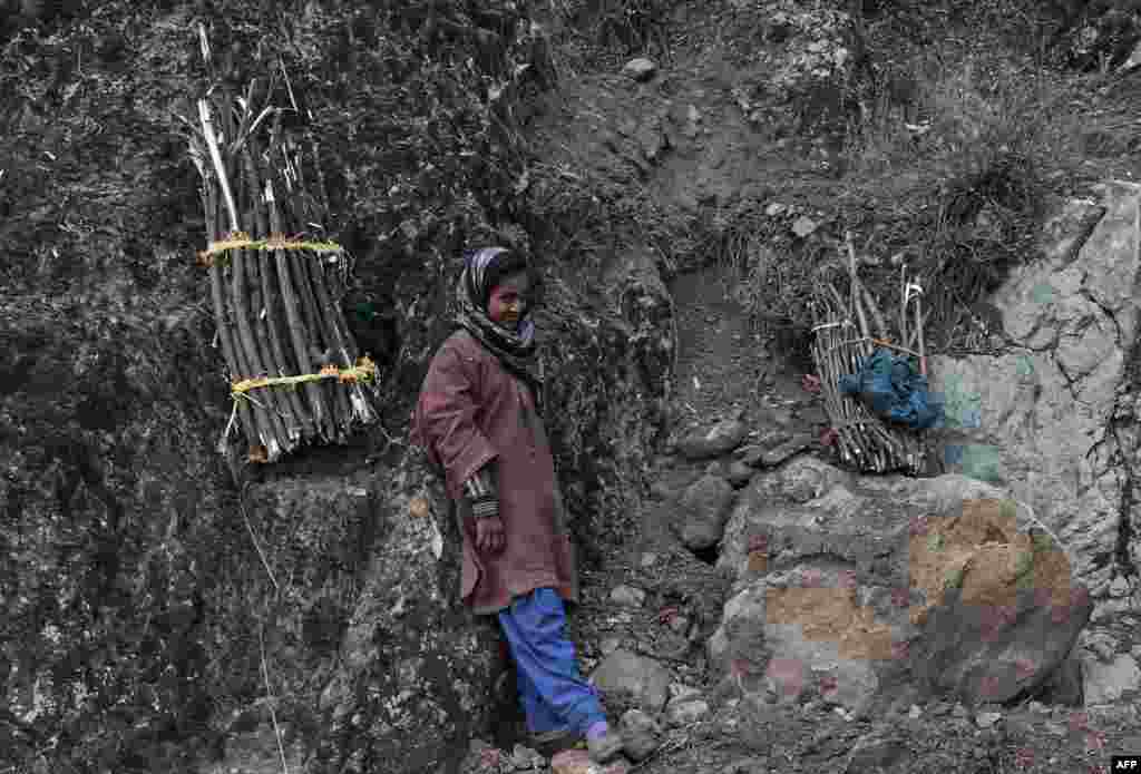 Seorang perempuan Muslim Kashmir beristirahat setelah mengumpulkan kayu bakar di Srinagar, Kashmir-India.