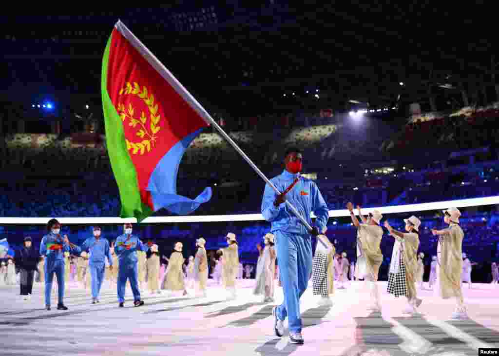 The Tokyo 2020 Olympics Opening Ceremony - Olympic Stadium, Tokyo, Japan - July 23, 2021. Flag bearer Ghirmai Efrem of Eritrea leads his contingent during the athletes&#39; parade at the opening ceremony REUTERS/Kai Pfaffenbach