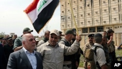 Iraqi Prime Minister Haider al-Abadi tours the city of Tikrit after declaring that it had been retaken from Islamic State militants by security forces, April 1, 2015.