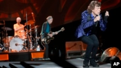 Mick Jagger, right, performs with Keith Richards, center, and Charlie Watts on drums as The Rolling Stones play in their "Zip Code" tour in Pittsburgh, June 20, 2015.