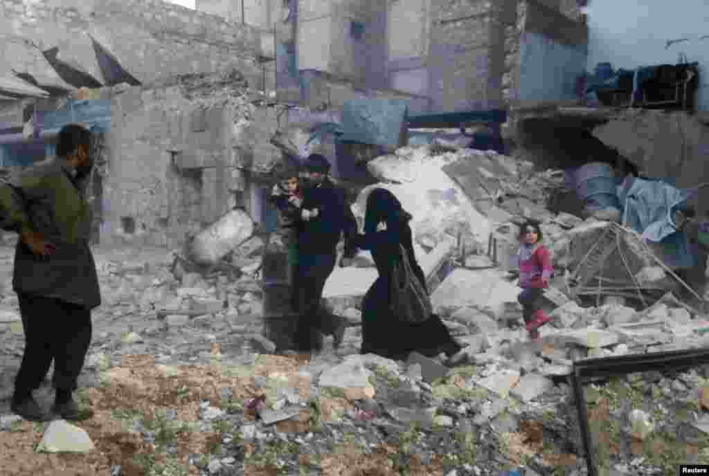 People walk on rubble of collapsed buildings at a site hit by what activists said were barrel bombs dropped by government forces in Aleppo, Syria, Jan. 29, 2014.&nbsp;