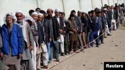 FILE - Afghan men line up to cast their votes during the parliamentary election at a polling station in Kabul, Afghanistan, Oct. 21, 2018. 