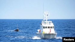 A Japanese coast guard patrol vessel tows a boat carrying nine people off the coast of Noto Peninsula, in northwestern Japan, Sept. 13, 2011. On Thursday, Japan returned to North Korea three crew members from a capsized fishing boat off the Noto Peninsula