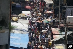 People crowd a street in a market on Lagos Island in Lagos, Nigeria, Oct. 11, 2011.