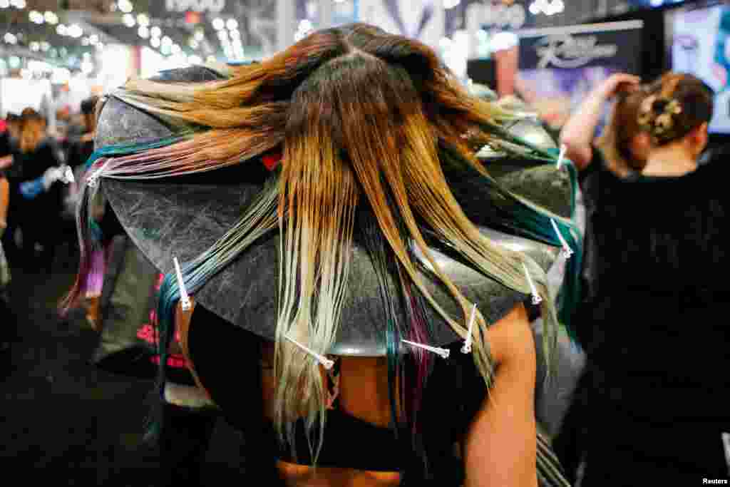 A woman has her hair done as people visit the International Beauty Show New York at Javits Center in New York, March 13, 2017.