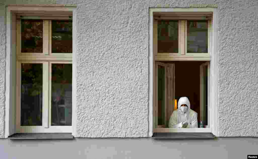 A medical staff member looks out of a window of a general practitioner&#39;s office which offers the coronavirus tests, as the COVID-19 spread continues in the Mitte district of Berlin, Germany.