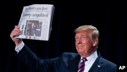 El presidente Donald Trump muestra el diario The Washington Post con el titular "Trump absuelto" durante el Desayuno Nacional de Oración" en Washington el jueves, 6 de febrero de 2020.