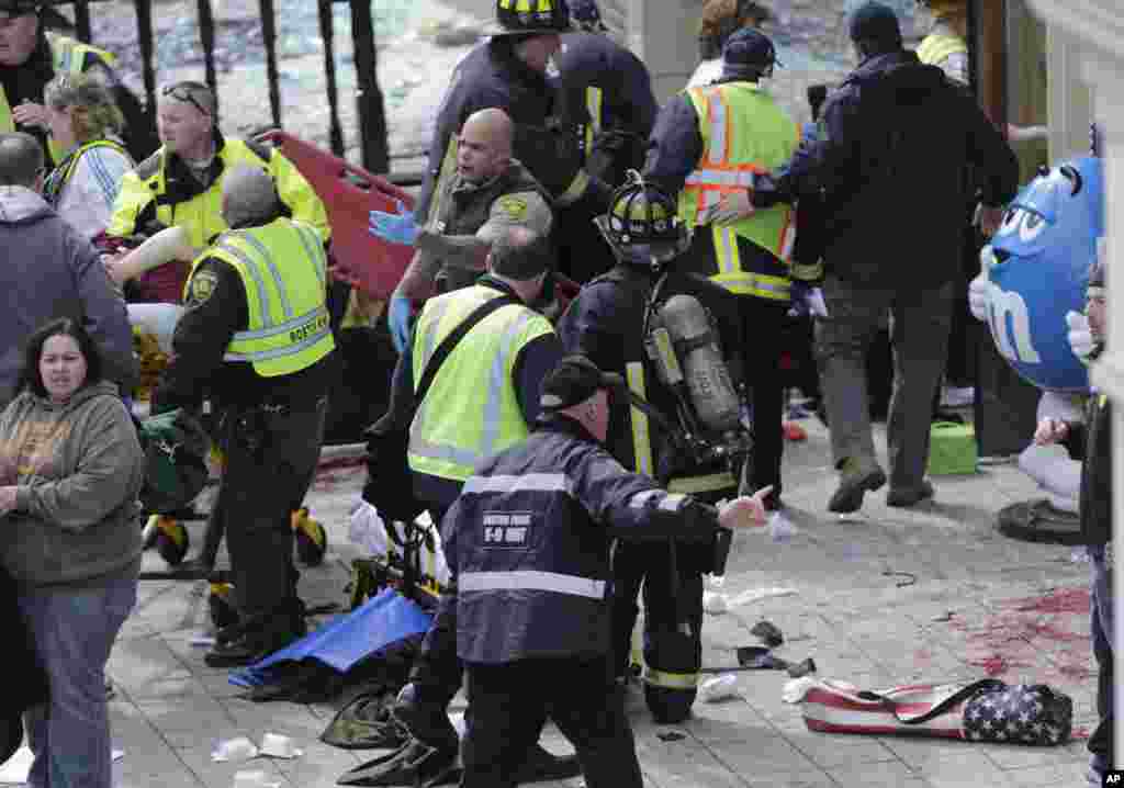 Medical workers wheel the injured across the finish line during the 2013 Boston Marathon following an explosion, April 15, 2013. 
