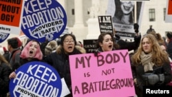 FILE - Pro-choice supporters demonstrate in front of the U.S. Supreme Court during the National March for Life rally in Washington, Jan. 22, 2016. The rally marks the 43rd anniversary of the U.S. Supreme Court's 1973 abortion ruling in Roe v. Wade.