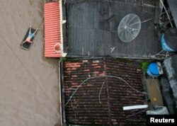 In a photo taken with a drone, a man is seen using an inflatable mattress during flooding caused by the overflowing Cachoeira river, in Itabuna, Bahia state, Brazil, Dec. 26, 2021.