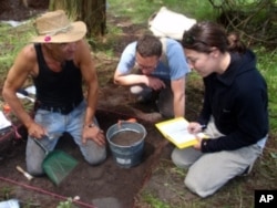 Colin Grier (center) discusses a find with graduate students Chris Arnett (left) and Kelly Derr (right).