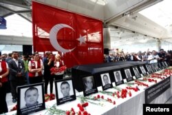 Airport employees attend a ceremony for their friends, who were killed in Tuesday's attack at the airport, at the international departure terminal of Ataturk airport in Istanbul, June 30, 2016.