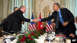 Prezidan Barack Obama (adwat) ap bay lanmen avèk Prezidan Recep Tayyip Erdogan, lidè Latiki a, aprè yo te fin rankontre nan vil Pari, an Frans, nan jounen madi premye desanm 2015 la.