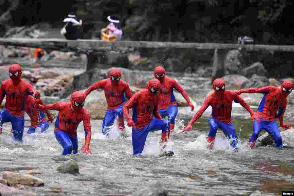 Participants dressed in Spiderman costumes run in a creek during an event at the Jiulongjiang National Forest Park in Chenzhou, Hunan province, China, July 4, 2019.