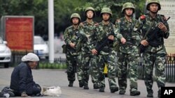 Lực lượng an ninh chính phủ tuần tra trên đường phố trong tỉnh Tân Cương.