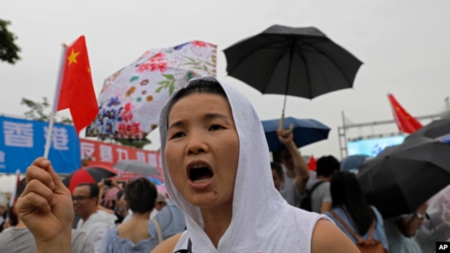 A pro-China supporters wave a Chinese national flag to support police and anti-violence during a rally in Hong Kong Saturday, Aug. 17, 2019. (AP Photo/Vincent Yu)