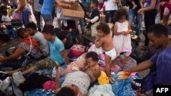 Migrantes hondureños que forman parte de una caravana hacia Estados Unidos descansan en la plaza principal de Tapachula, México. 