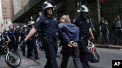 Police officers take away a protester during an Occupy Wall Street march at the New York Stock Exchange in Manhattan, Sept. 17, 2012.